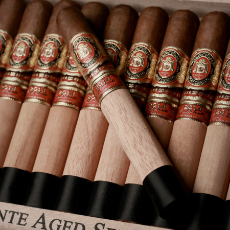 This exclusive bundle includes a box of 10 Don Carlos Edicion de Aniversario Toro cigars, paired with two Opus X Forbidden X Amor Sensual cigars front cover opus x cigar aniversario toro cigars box